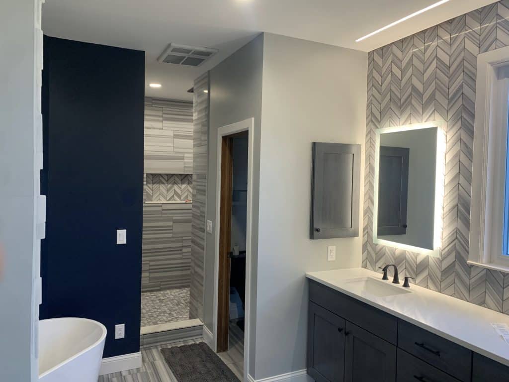 A beautifully refinished kitchen in Wichita, KS, featuring a two-tone cabinet design with satin white upper cabinets and matte black lower cabinets. The quartz countertops and modern fixtures highlight the sleek, professional craftsmanship of Roll Call Painting's expert kitchen cabinet refinishing services.