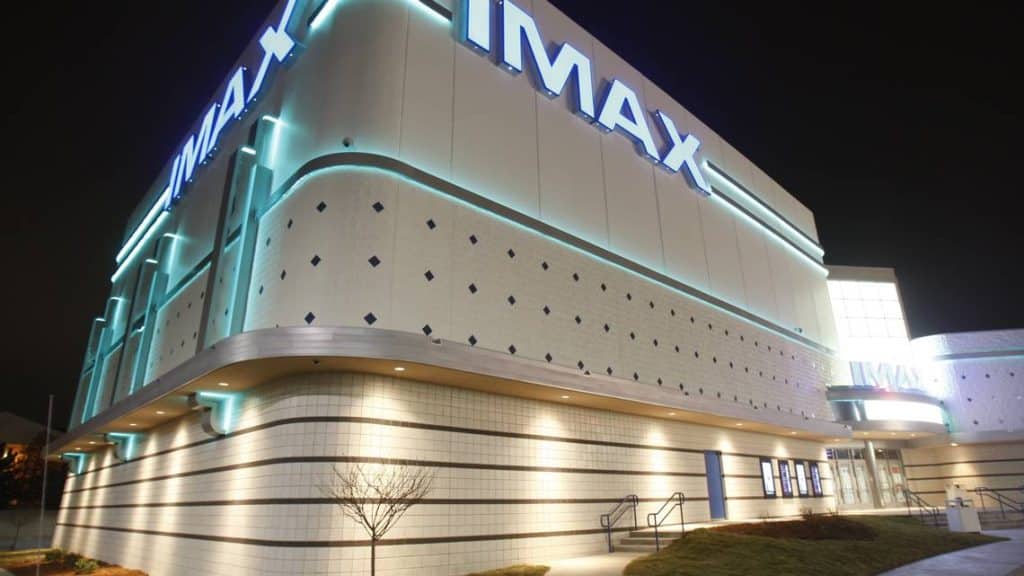 A modern IMAX theater in Wichita, KS, featuring a sleek exterior with professional commercial painting. The bright lighting and clean finish highlight the quality and durability of the paintwork, completed by Roll Call Painting.