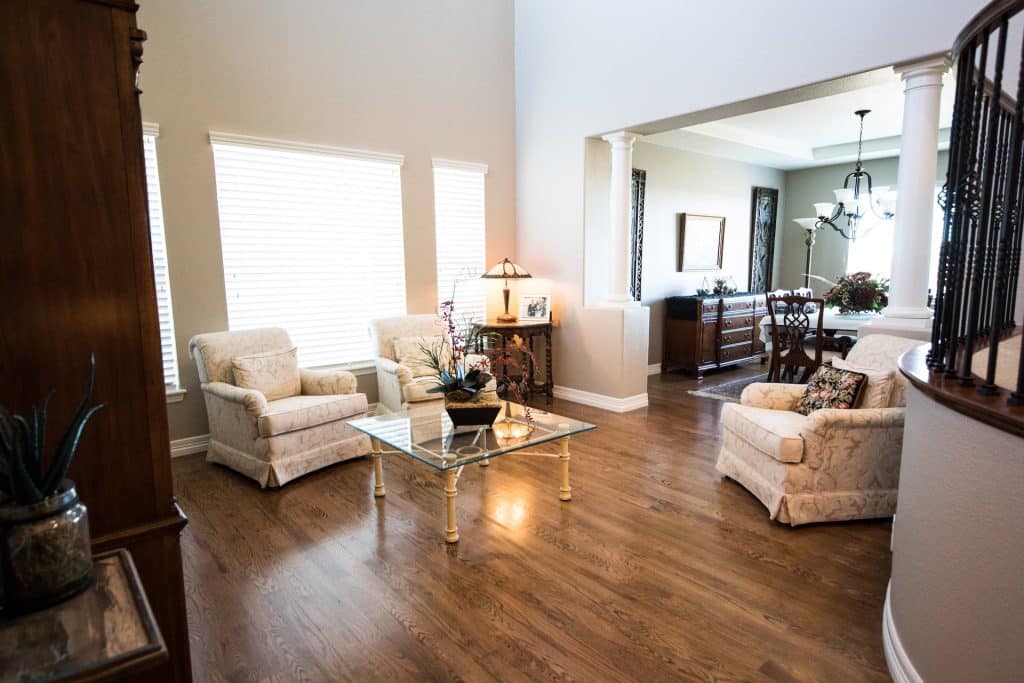 A professional painter in Wichita, KS, applying primer to a home’s interior wall, ensuring a smooth and even base for high-quality paint application. The workspace is neatly prepped with floor coverings and painter’s tape.