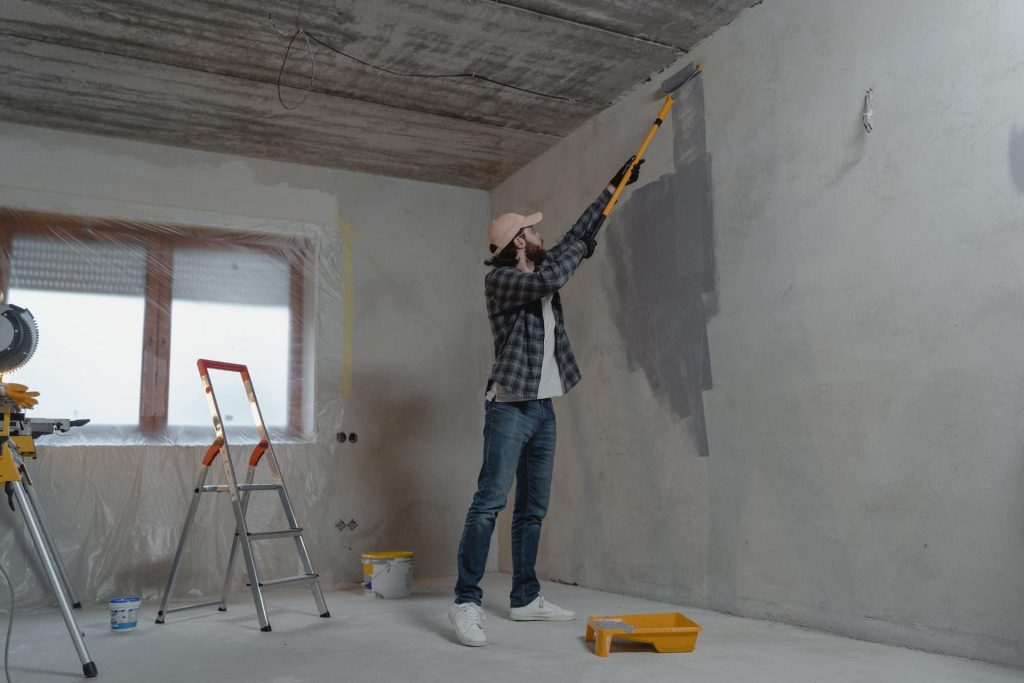 A professional painter working on a commercial interior wall in Wichita, KS, using high-quality materials for a flawless finish. Roll Call Painting specializes in transforming office and retail spaces with expert painting services.