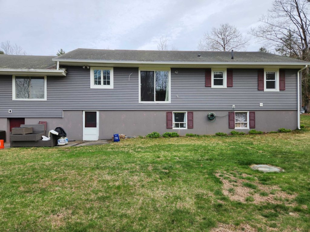 Gray house with lawn and patio furniture.