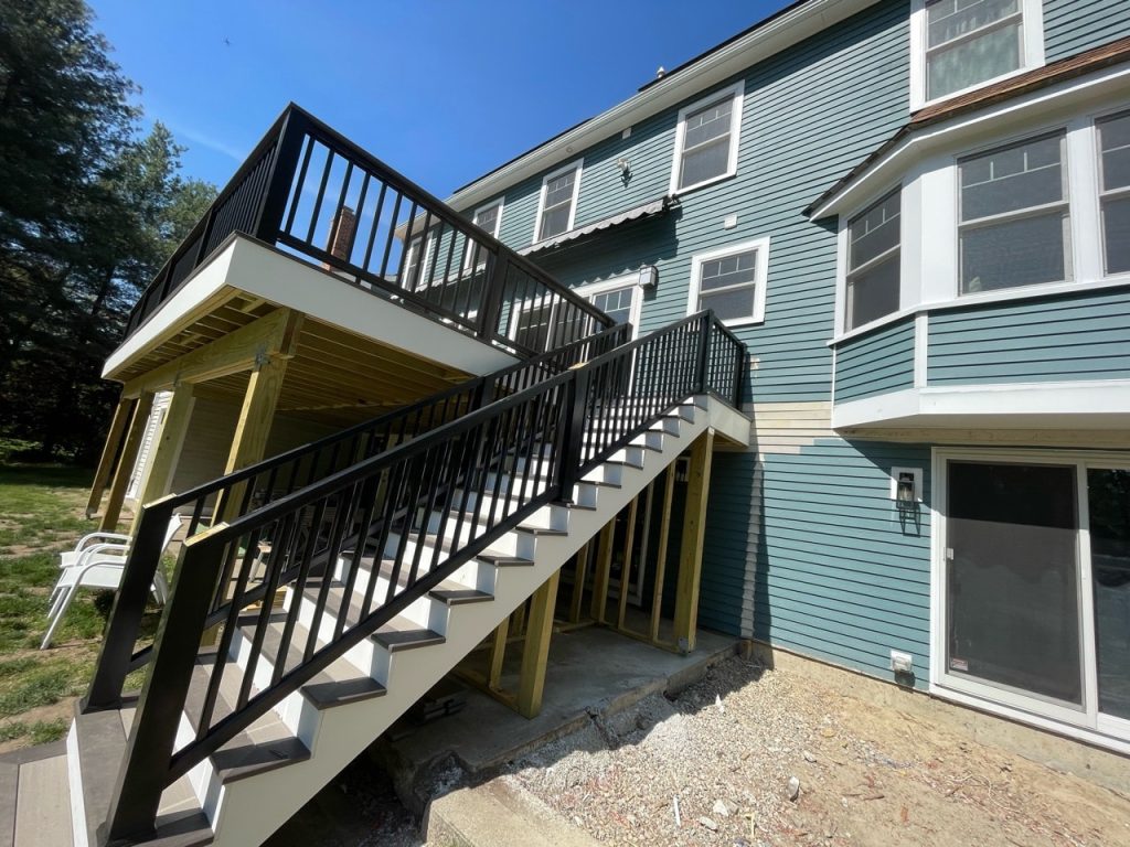 Newly constructed outdoor deck with stairs and railing.