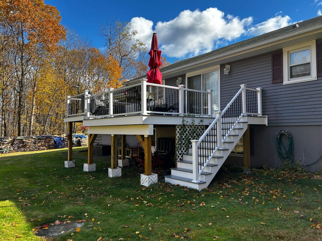 Elevated patio with stairs in autumn backyard.