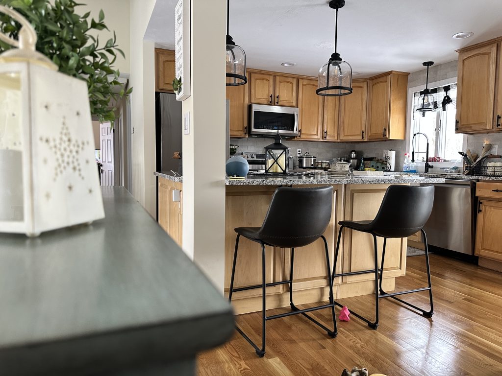 Modern kitchen with wooden cabinets and bar stools.