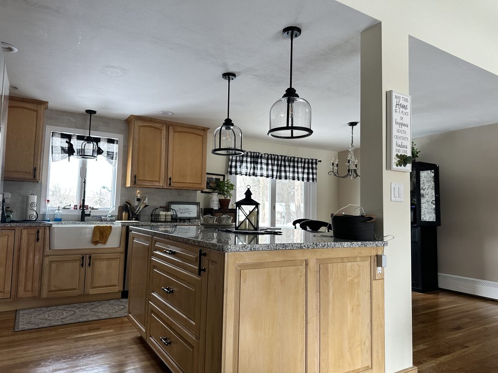 Modern kitchen with wood cabinets and pendant lights.