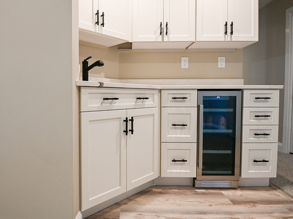 Modern kitchen with white cabinets and wine cooler.